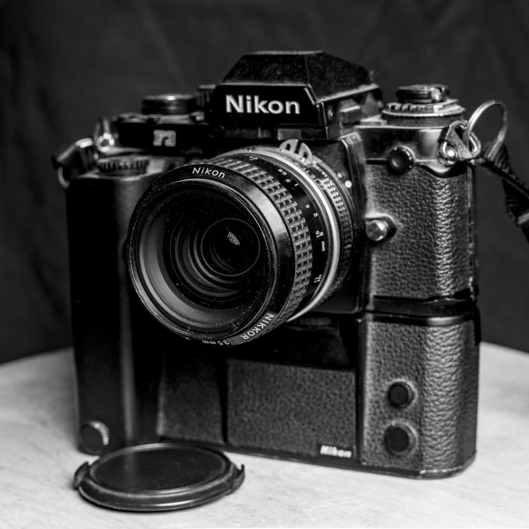 A black and white photograph of a Nikon F3 film camera